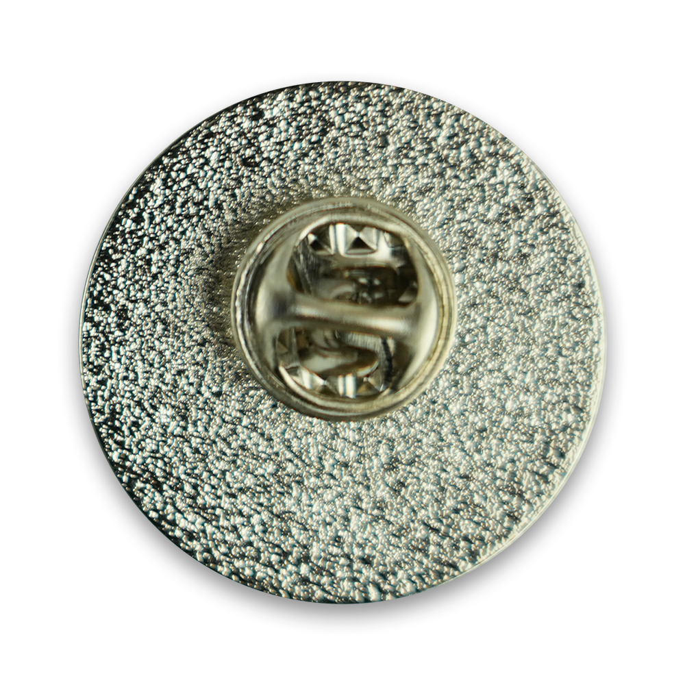 Circular metallic lapel pin with a textured surface and central fastener.